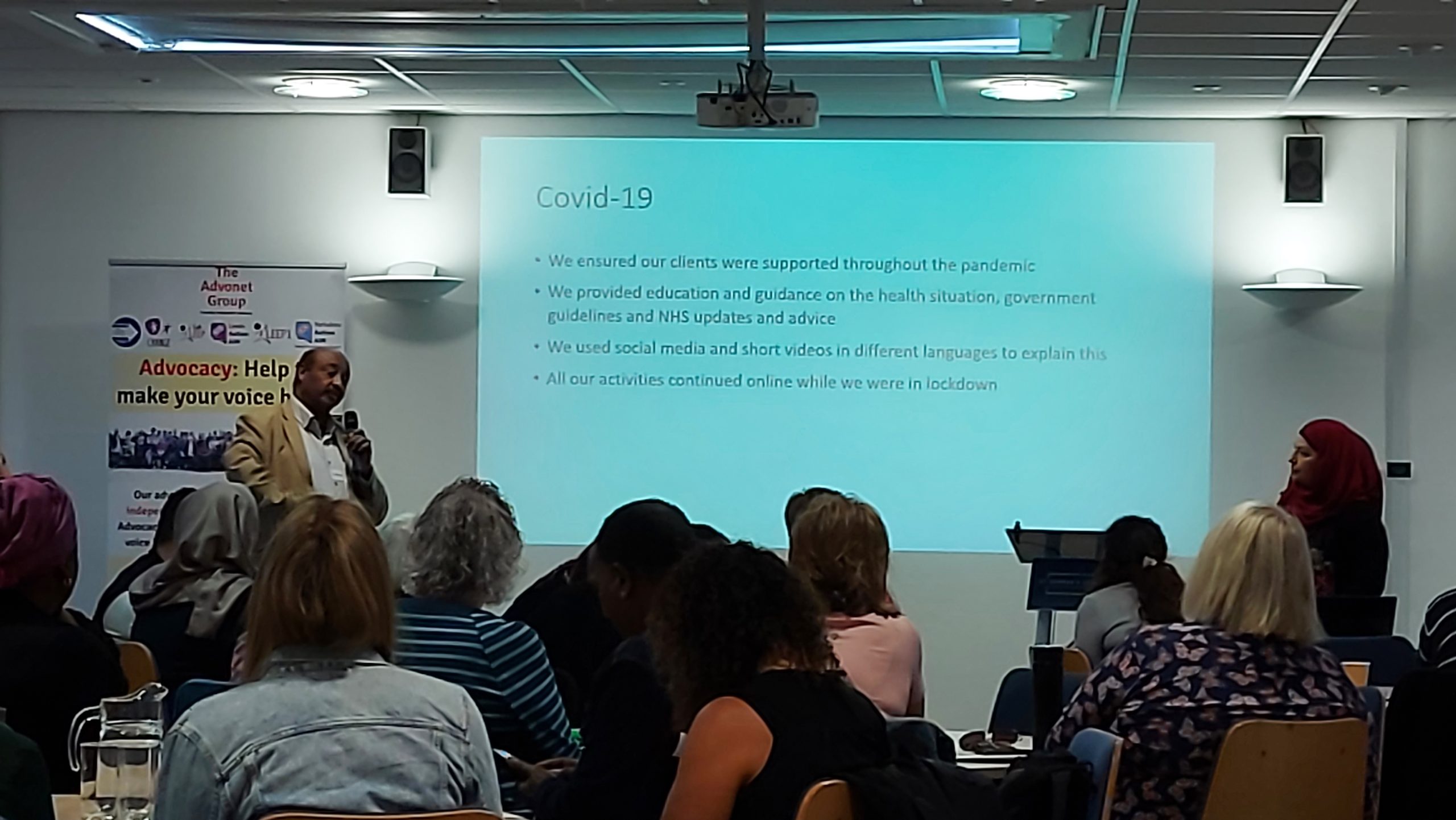 Ali from Leeds Refugee Forum, speaking in front of people about the impact of COVID-19 on the clients they worked with. This was at our Advocacy Development Fund event.