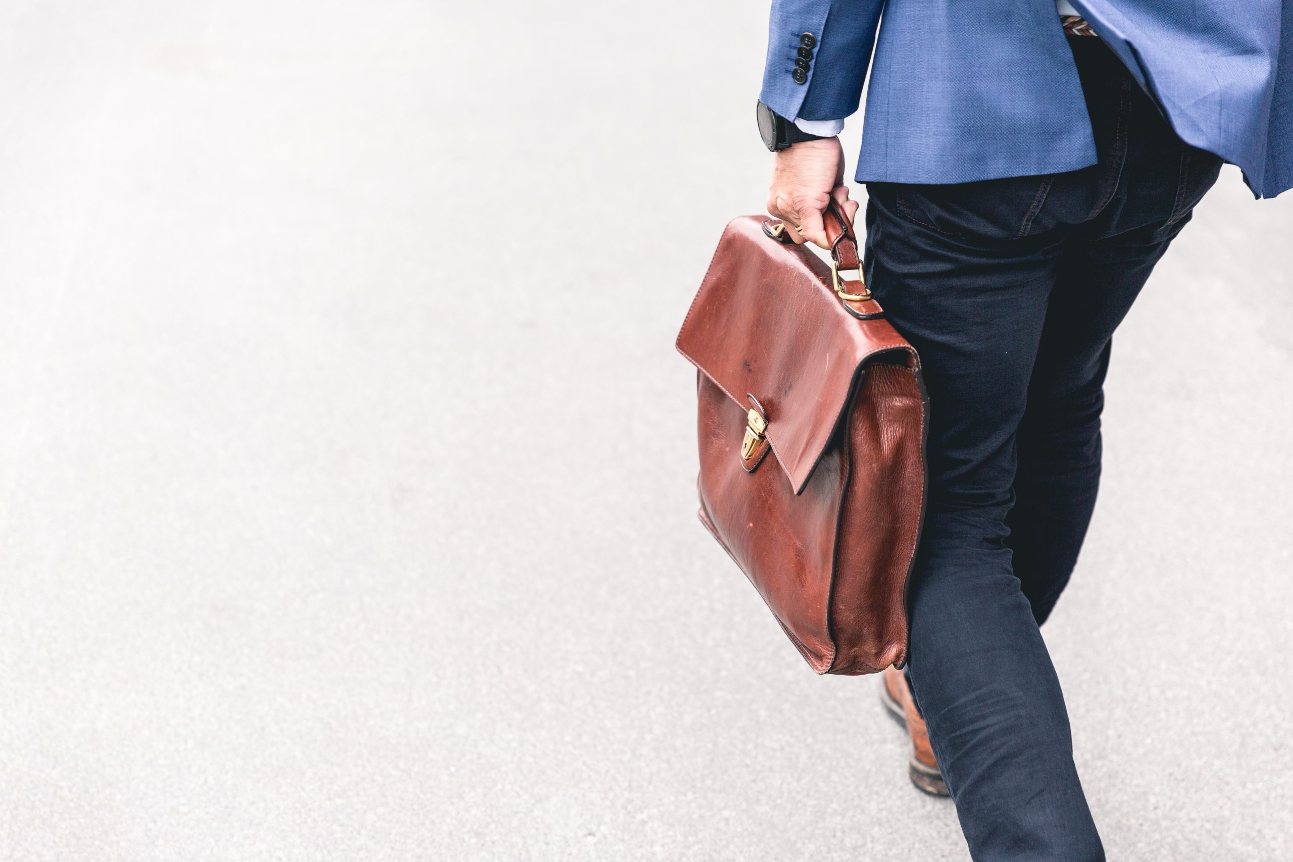 A person carrying a brown handbag on their way to work