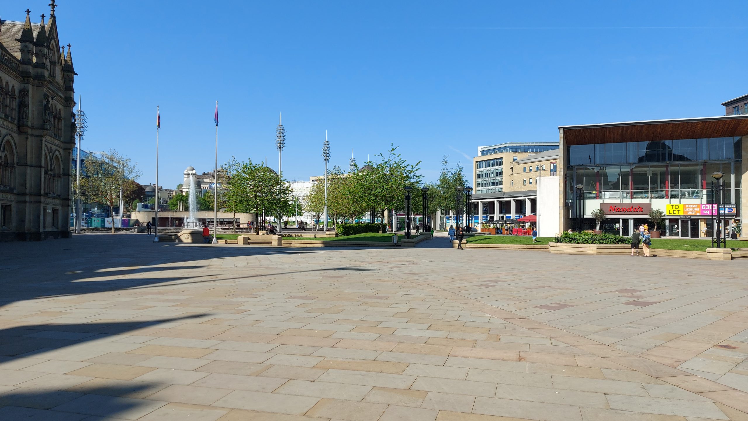 A photo of the City Park in Bradford City Centre. There is part of Bradford City Hall on the left and a restaurant on the right.