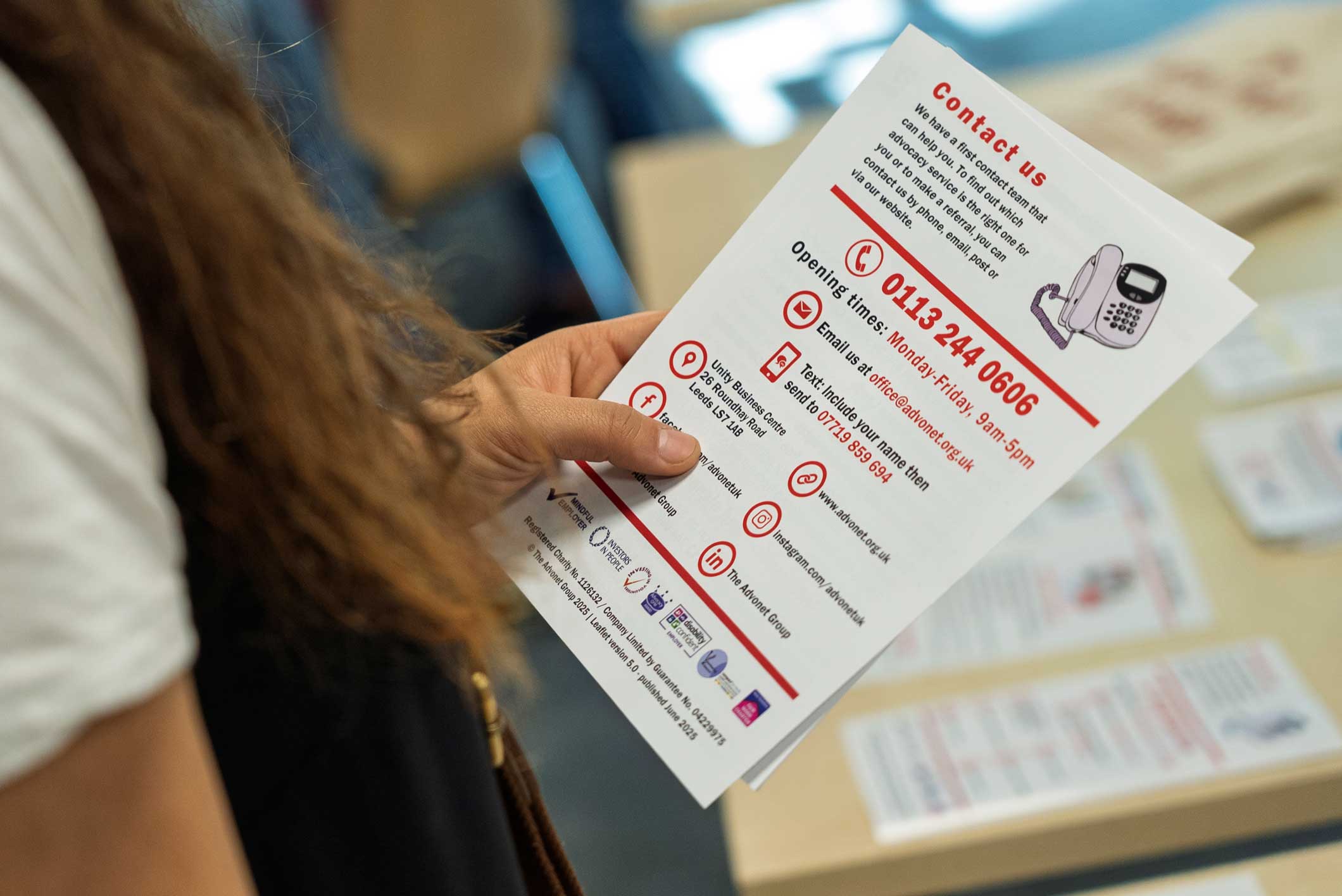 A photo of someone holding a leaflet about our advocacy services with their left hand.