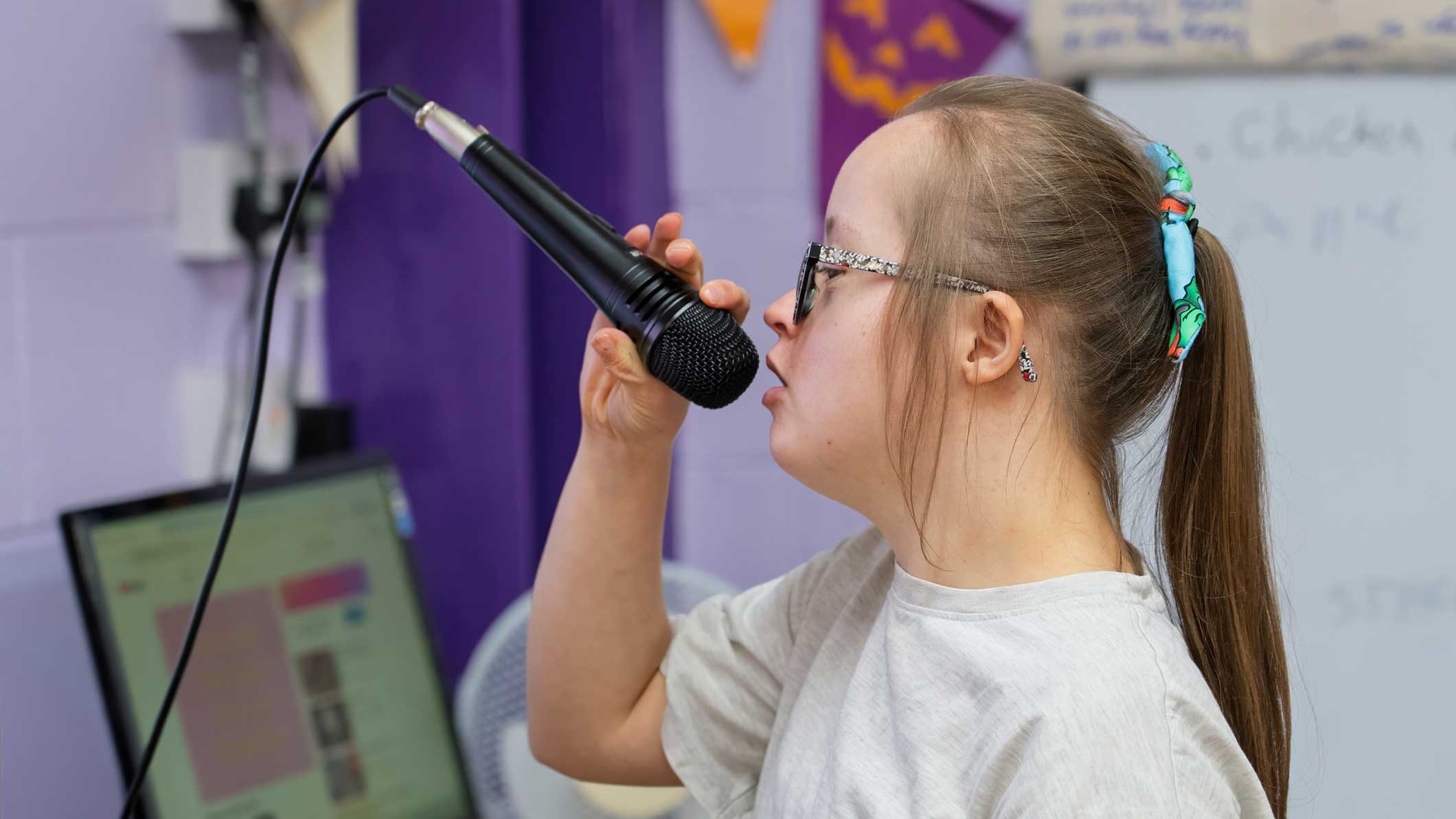 A photo of a young woman doing karaoke, holding a microphone